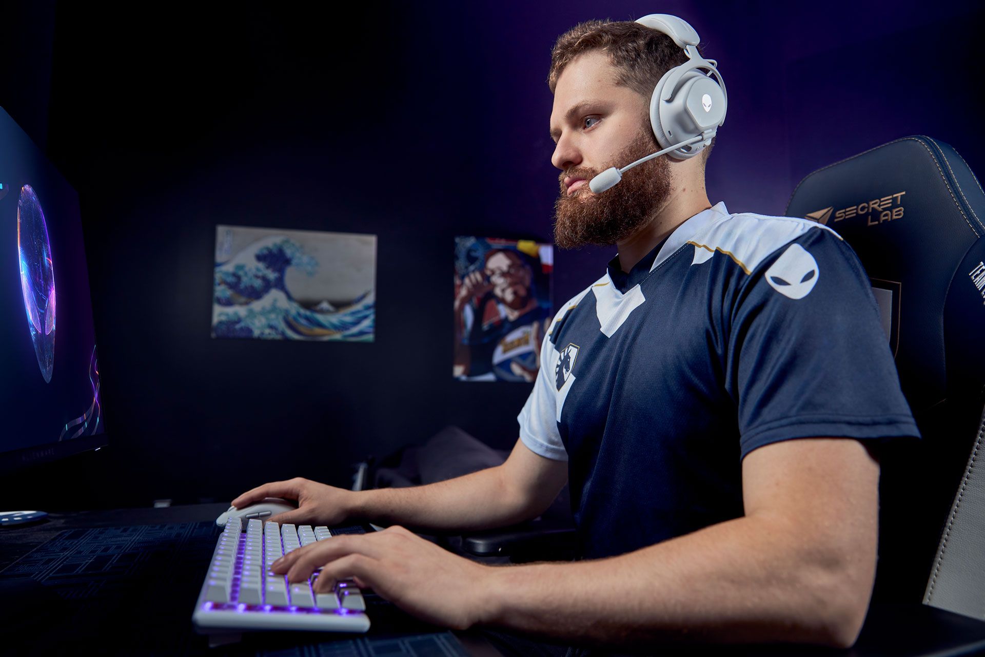 A person wearing headphones and a blue shirt sitting at a computer

Description automatically generated